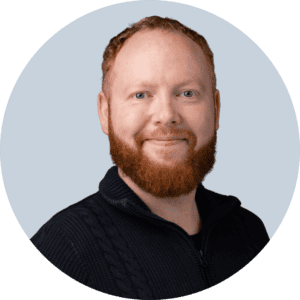 Professional man with red hair and beard smiling for startup webinar promotional image.