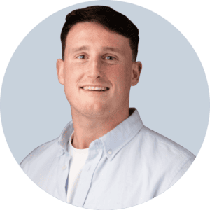 Professional man smiling in a light blue shirt for startup webinar.